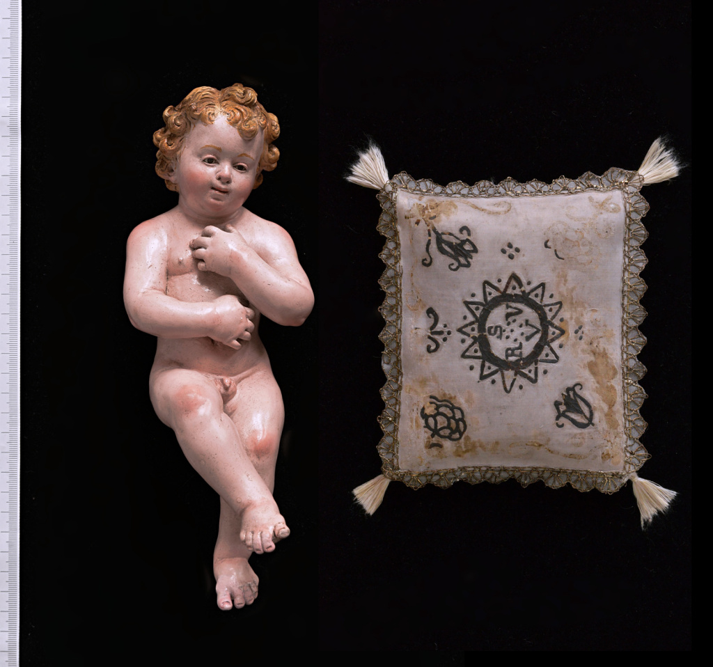 Figurka Dzieciątka Jezus (684/MMZ) oraz poduszka, na której ułożona była figura, przód, wys. 24,5 cm, stan po konserwacji